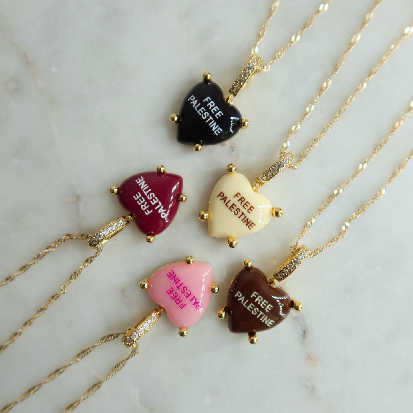 Necklaces with heart-shaped pendants on a marble surface