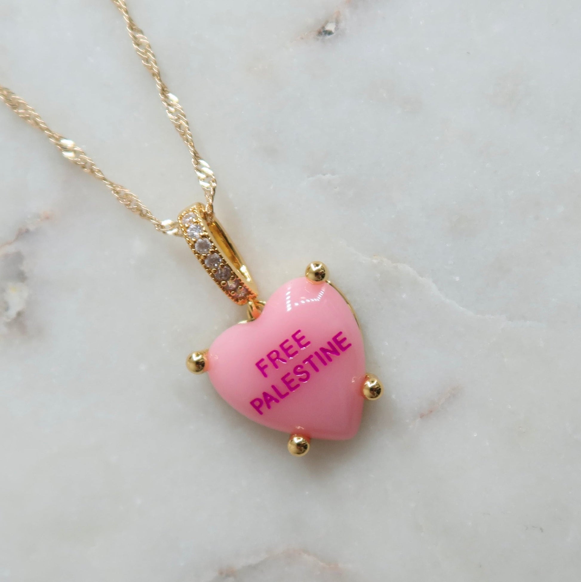 Heart-shaped pink pendant necklace on a marble surface